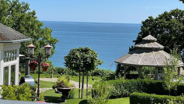 A coastal view with a gazebo, a white building, and a garden with a fountain. - Villa Seestern, apartment 1 - pure sea view! - Villa Seestern, vacation apartment 1 - (Sassnitz)