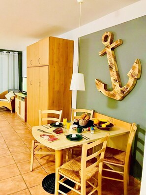 Ein Essbereich mit einem Holztisch, Stühlen und einer Wanddekoration als Anker.