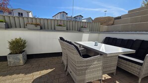 An outdoor patio with wicker furniture, a table, and potted plants. - Seemeile 1 - Villa Monika - Villa Monika, App. Seemeile 1 with terrace (Sassnitz auf Rügen)