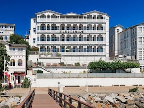 A multi-story building with balconies, a sign reading 'FURSTENHOFF,' and a wooden walkway leading to it. - Fürstenhof, App.104 - First row by the sea - Fürstenhof, App. 104 - First row (Sassnitz auf Rügen)