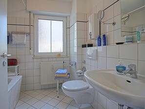 Un baño con inodoro, lavamanos y ventana.