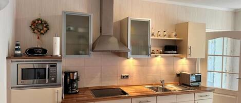 Una cocina moderna con microondas, cafetera y horno empotrado.