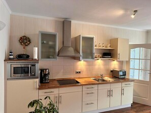 Eine moderne Küche mit Mikrowelle, Kaffeemaschine und Backofen.