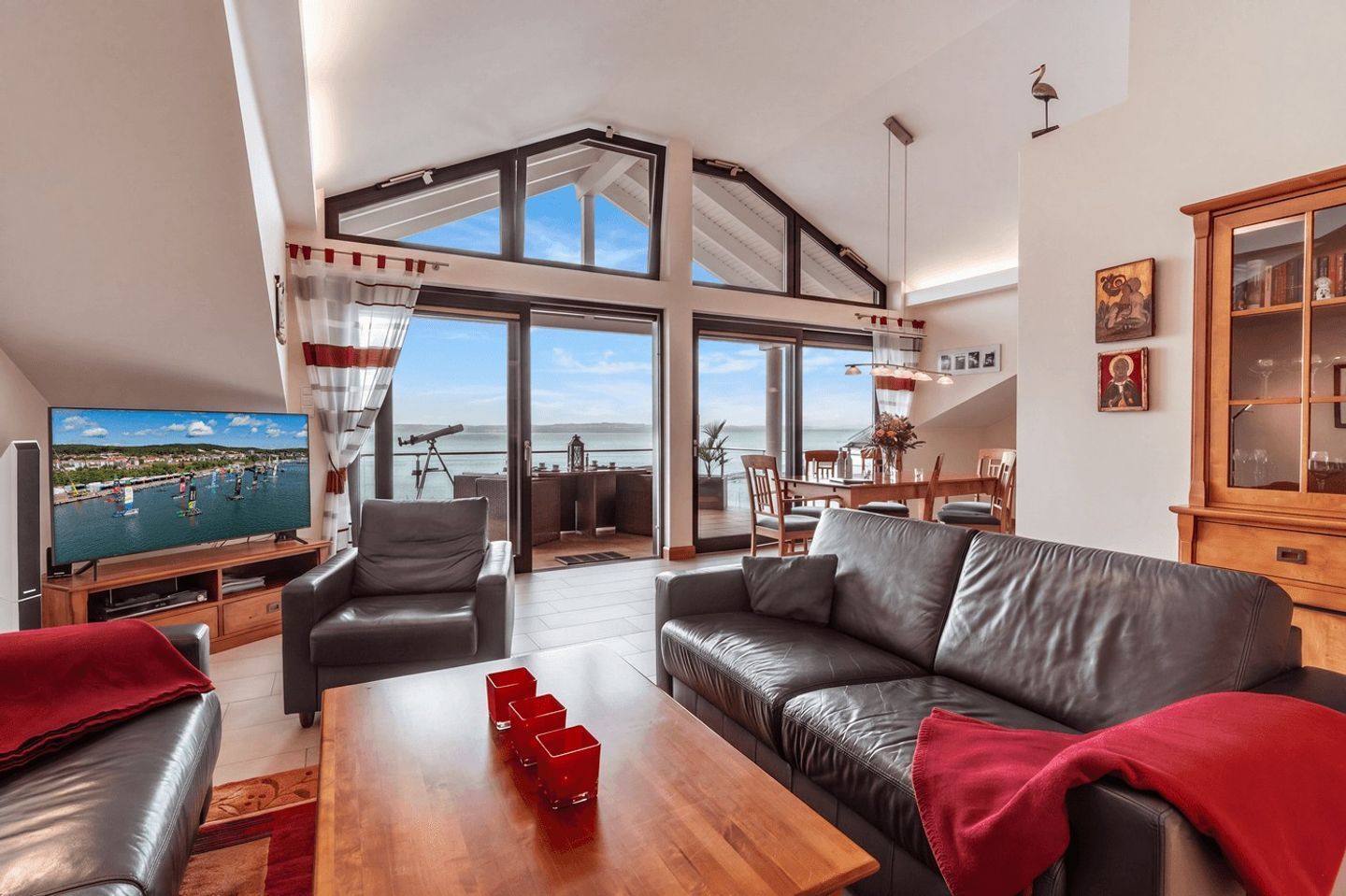A spacious living area with a large TV, leather sofas, and a wooden coffee table.