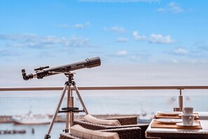 A telescope on a balcony with a view of the sea and a distant ship. - Villa Friede-Marie - Penthouse Sophie - Villa Friede-Marie, Penthouse Sophie - (Sassnitz auf Rügen)