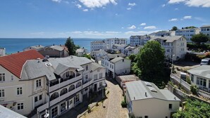 Una cittadina costiera con edifici, strade acciottolate e vista sul mare.