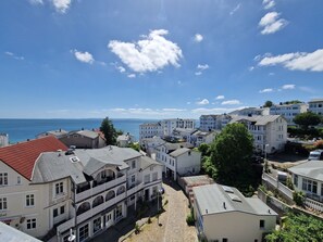 Eine Küstenstadt mit Gebäuden, Kopfsteinpflasterstraßen und Blick auf das Meer.