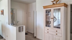 Eine Küche mit einem eingebauten Kühlschrank, einem Holzkabinett mit Glastüren und einem Holzboden.