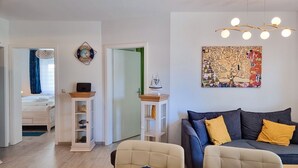 Ein modernes Wohnzimmer mit einer Couch, einem Esstisch und einem Bücherregal.