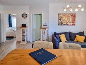 Ein modernes Wohnzimmer mit einer Couch, einem Esstisch und einem Bücherregal.