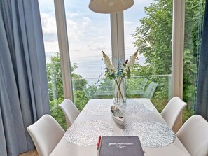 Ein Esstisch mit einer Blumenvase, einer Speisekarte und einem Glas Wasser.