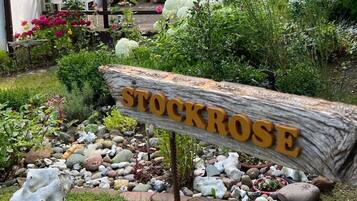 A garden with a wooden sign that reads 'STOCKROSE.'