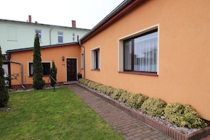 A residential building with a paved driveway, a small lawn, and a row of bushes along the side. - Vacation apartment Kollwitz - very close to the Sassnitz town harbor - Holiday apartment (Sassnitz auf Rügen)