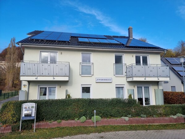 A two-story building with solar panels on the roof, balconies, and a sign reading 'Zum Kreideblick'. - Vacation home Zum Kreideblick, FeWo Seeigel (Sassnitz auf Rügen)