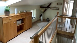 Una stanza in stile loft con finestra a lucernario, arredi in legno e vista sull'ambiente adiacente.