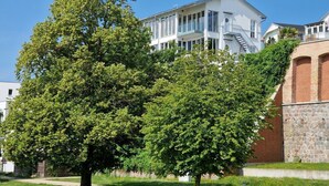Monikerroksinen rakennus, jossa on valkoinen julkisivu, suuret ikkunat ja selvästi näkyvä portaikko, joka johtaa ylemmälle tasolle.