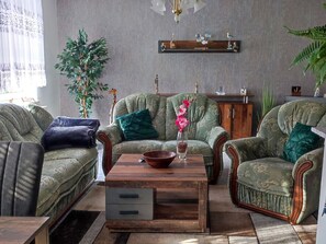 Ein Wohnzimmer mit einer Sofagarnitur, einem Couchtisch und Dekorationselementen.