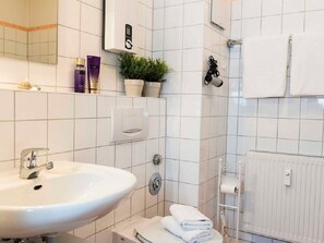 Uma casa de banho com lavatório, porta-toalhas, sanita e radiador.