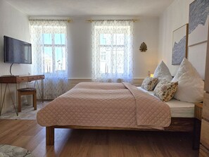 A bedroom with a bed, a desk, and a TV. - Vacation apartment in Haus Amalie - Holiday apartment in Haus Amalie - close to the beach in (Sassnitz auf Rügen)