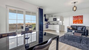 Un appartement moderne doté d’un balcon, d’un coin repas, d’un salon et d’une cuisine.