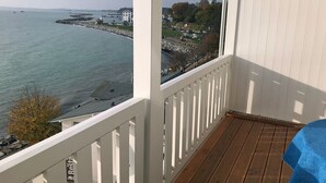 Un balcone con vista sul mare e su una cittadina costiera.