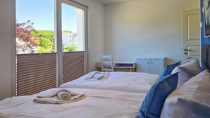 Ett hotellrum med två sängar, ett skrivbord och utsikt över omgivningarna.