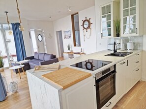 Eine moderne Küche mit integriertem Backofen, einer Holz Arbeitsplatte und einer Schiffslücke als Dekoration.