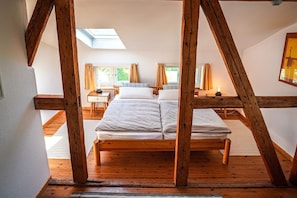 Ein Zimmer mit einem hölzernen Bett, einem Oberlicht und Blick ins Freie.