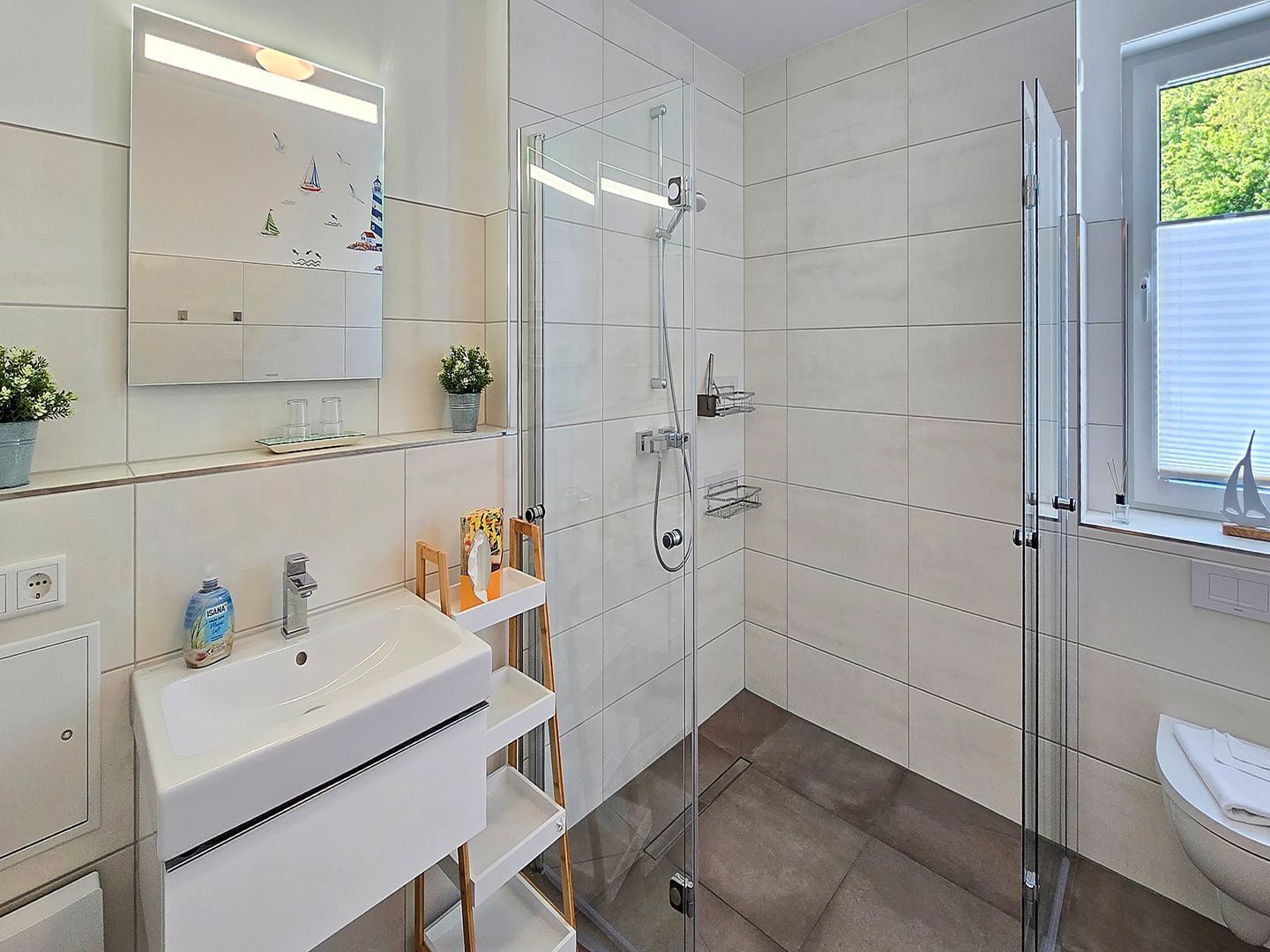 A modern bathroom with a glass shower enclosure, a white sink, and a window with a view.