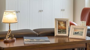 A wooden table with a lamp, two framed pictures, and a book. - Villa am Kreidebruch, FeWo OstseeWeitblick - panoramic view of the Baltic Sea (Sassnitz auf Rügen)