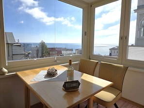 Ein Zimmer mit Tisch, Stuhl, einer Flasche und einem Schild mit der Aufschrift 'Wilkommen'.
