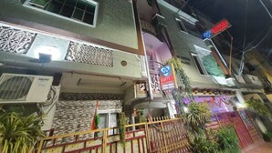 Un edificio de varios pisos con un cartel que dice 'Suites AIC Rooms' y un número de contacto.