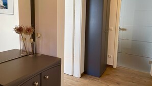 A room with a dark cabinet, a door, and a framed picture on the wall. - Vacation apartment Seestern - Holiday apartment Seestern in Sassnitz on Rügen with (Sassnitz auf Rügen)
