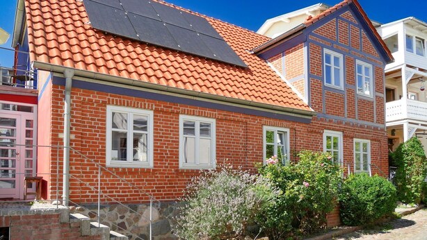 A two-story brick house with a red-tiled roof and solar panels. - Vacation apartment Zum Strandvoigt (Sassnitz auf Rügen)