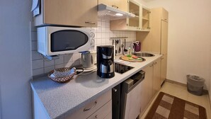 A compact kitchen with a microwave, coffee maker, and a sink. - Ferienhaus Zum Kreideblick, FW Seepferdchen - Holiday home Zum Kreideblick, (Sassnitz auf Rügen)