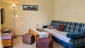 A living room with a sofa, a coffee table, a lamp, and a framed picture on the wall. - Ferienhaus Zum Kreideblick, FW Seepferdchen - Holiday home Zum Kreideblick, (Sassnitz auf Rügen)