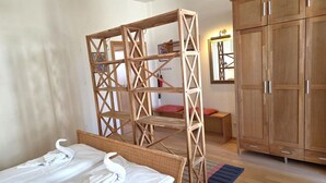 Un dormitorio con una cama, un armario de madera, un espejo y una división de madera.