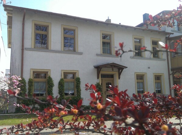 Un edificio de varios pisos con fachada simétrica, múltiples ventanas y una entrada central.