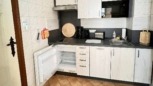 A compact kitchen with white cabinets, a microwave, a toaster, and a sink. - Apartment 2 Otto - in the center of Sassnitz - Apartment 2 - only (Sassnitz auf Rügen)