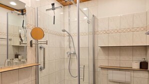 Un baño moderno con ducha de vidrio, lavamanos y espejo.