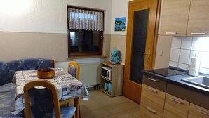 A compact kitchen with a dining area, a coffee machine, and a radiator. - Vacation apartment near the Bodden - Holiday apartment near the Bodden - idyllic on the large (Glowe OT Polchow)