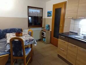 A compact kitchen with a dining area, a coffee machine, and a radiator. - Vacation apartment near the Bodden - Holiday apartment near the Bodden - idyllic on the large (Glowe OT Polchow)