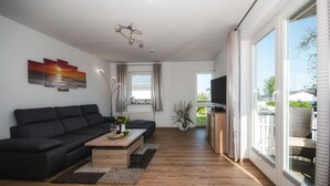 Een moderne woonkamer met een bank, salontafel en televisie.