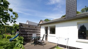 A house with a deck, a slide, and a window. - Ferienzimmer am Försterberg - Holiday room Am Försterberg, on the edge of the (Lohme OT Hagen)