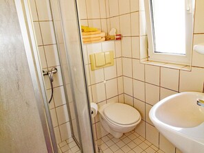 Ein Badezimmer mit Dusche, Toilette und Waschbecken.