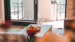 A dining area with a table set for two, a bowl of fruit, and two wine glasses. - Villa Friede-Marie, App. Baltic Sea view - with fantastic sea view - Villa (Sassnitz auf Rügen)