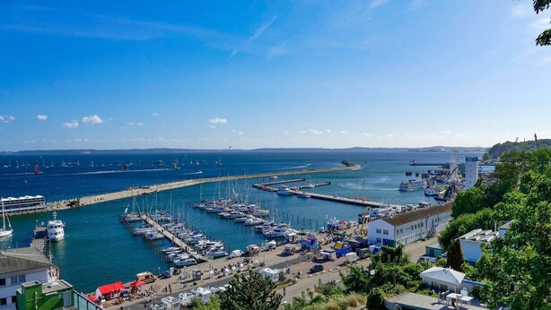 Un port de plaisance avec des bateaux amarrés, une jetée et un bâtiment doté d’un toit plat.