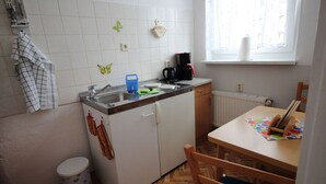 A compact kitchen with a sink, a coffee maker, and a window. - Apartment Thurk - centrally located in the harbor town of Sassnitz (Sassnitz auf Rügen)