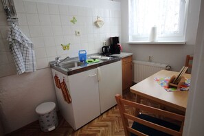 A compact kitchen with a sink, a coffee maker, and a window. - Apartment Thurk - centrally located in the harbor town of Sassnitz (Sassnitz auf Rügen)