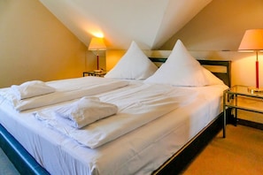 A hotel room with a large bed, two bedside tables, and two lamps. - Vacation apartment Moritz - vacation in a quiet location with dog (Neddesitz auf Rügen)